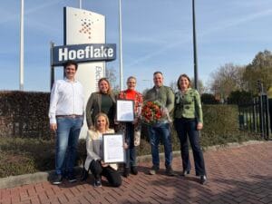 Groepsfoto voor het Hoeflake-bord ter gelegenheid van de ISO27001 certificering uitreiking